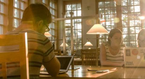 UNH学生在图书馆的桌子上用笔记本电脑学习
